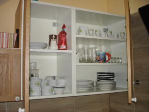 a cabinet filled with plates and cups and dishes at Ferienwohnung Anna in Semmering