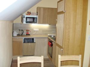 a small kitchen with two chairs and a microwave at Ferienwohnung Anna in Semmering