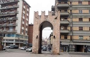 a brick archway in front of a tall building at Bab San Feliciano Camere Foligno in Foligno