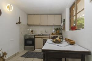 a kitchen with a table with a bowl of fruit on it at Rasopasno 2 in Malinska