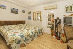 a bedroom with a bed and a tv in it at Rasopasno 2 in Malinska