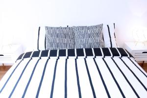 a black and white bed in a bedroom at NEW Central Light Apartment with Private Parking in Novi Sad