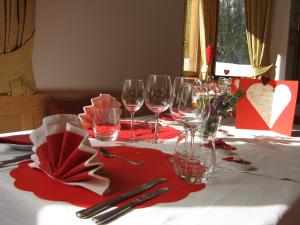 a table topped with wine glasses and red napkins at Hotel Chalet Giasenei in Sagron Mis