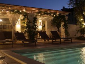 un patio con sedie e una piscina di notte di Masseriola Antiche Fogge a Fasano