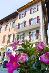 Um edifício com flores cor-de-rosa à frente. em LA QUADRA SUITES - Central Apartments in Iseo em Iseo