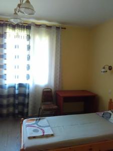 a bedroom with a bed and a window and a desk at Fenix Rooms in Arbanasi