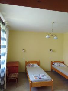 Habitación con 2 camas y silla en Fenix Rooms, en Arbanasi