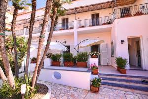 a house with palm trees in front of it at Villa Giardini Luxury Room in Capri