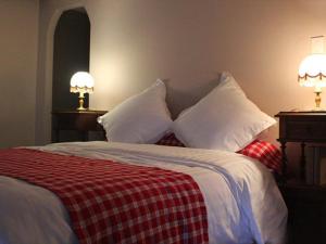 a bedroom with a bed with pillows and two lamps at A l'ombre du verger in Breitenau