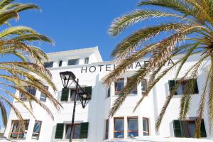 een hotel met palmbomen ervoor bij Hotel Marina in Port de Soller