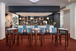 a kitchen with a bar with blue chairs and tables at Hotel Pestana Cascais Ocean & Conference Aparthotel in Cascais