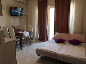 a living room with a bed and a dining room at Barać in Kaštela