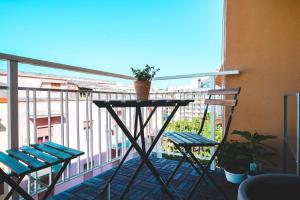 einen Balkon mit zwei Stühlen und einem Tisch mit einer Pflanze darauf in der Unterkunft Cloud House Sicily in Syrakus