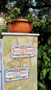 Una señal que dice casa de los Ringers y una maceta de flores. en Rina's House en Kalabaka