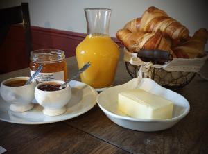 a table with two plates of butter and a basket of bread at L'Auberge de Teissières in Teissières-lès-Bouliès