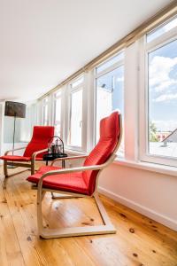 2 sillas y una mesa en una habitación con ventanas en Cozy Studio Mansard Riga Old Town Aptartment, AC en Riga