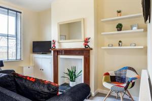 a living room with a couch and a fireplace at Cloud View Cottage in Congleton