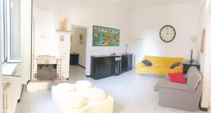 un salon avec un canapé et une horloge au mur dans l'établissement Casa Ada a Marina di Cecina by Zoom In Earth, à Marina di Cecina