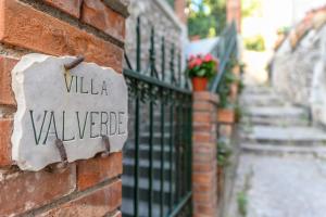 un cartello sul lato di un muro di mattoni con una villa villelez di Villa Valverde Apartments e B&B a Taormina