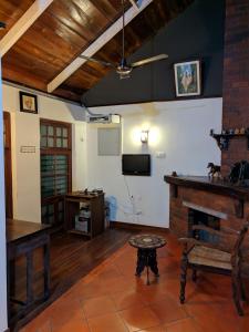 a living room with a fireplace and a tv at ADRI CHEMBRA in Meppādi