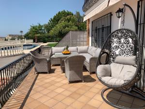 a patio with wicker chairs and a couch on a balcony at Apartaments Bastion in Torremolinos