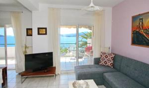 un salon avec un canapé et une télévision dans l'établissement Coral Suite, à PalaiónTsiflíkion