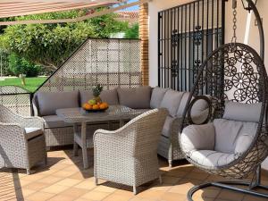 a patio with a swing and a table and chairs at Apartaments Bastion in Torremolinos +3 photos
