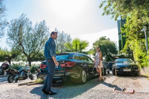 a man and a woman standing next to a car at Hotel Miramare - Adults Only in Trieste