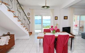 une salle à manger avec une table et des chaises rouges dans l'établissement Coral Suite, à PalaiónTsiflíkion