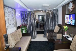 un soggiorno con divano, tavolo e TV di Moskva Hotel a Madurai