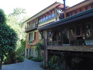 a brick house with a balcony on the side of it at Casa D`Irene - Zen Space in Cachoeiras de Macacu