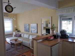 a living room with a white couch and a table at Apartment Satus in Podstrana