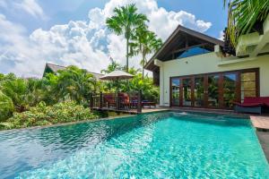 a villa with a swimming pool and a house at Boutique hotel villa Cantik and karma beach club in Uluwatu