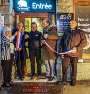 un grupo de personas de pie en frente de una tienda en Le Grizzly Luxe Location, en Font-Romeu