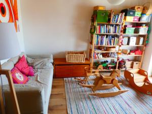 uma sala de estar com um sofá e uma estante de livros em Ferienwohnung Bodensee Bullerbü em Eigeltingen