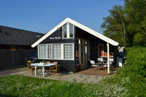 a small black house with a table and chairs at Riviera Marielle in Zoutelande