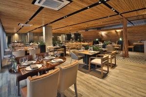 a restaurant with wooden ceilings and tables and chairs at Movich Buro 51 in Barranquilla