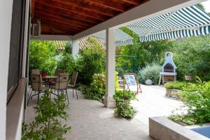 d'une terrasse avec une table et des chaises sous une pergola. dans l'établissement 50 meters from the beach! Apartment Flower, à Kaštela