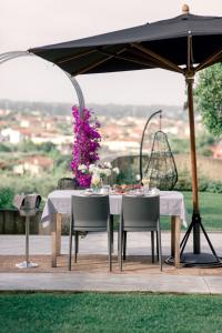 a table and chairs under an umbrella on a patio at Relais Montepepe Winery & Spa in Montignoso