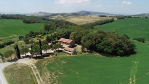 an aerial view of a house in a green field at Locanda il Boschetto in Volterra