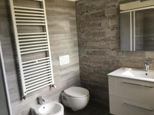 a bathroom with a toilet and a sink and a mirror at AMLÈ in Papozze +21 photos