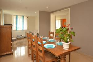 a dining room with a wooden table and chairs at L'annexe de la Pétillante 101 Rue Principale in Soudron