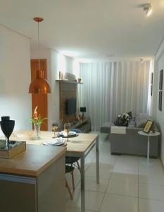 uma cozinha e sala de estar com uma mesa e um sofá em Apartamento 2 quartos a 4 minutos do mar de Maceió em Maceió