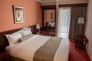 Cette chambre comprend un grand lit et une fenêtre. dans l'établissement Hotel Pella, à Giannitsá
