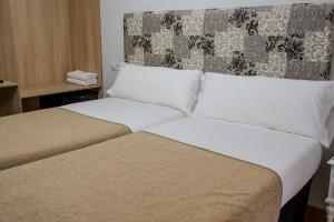 En eller flere senge i et værelse på Pensión Laurel