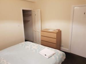 a small bedroom with a bed and a dresser at Woodard House in Woodchurch