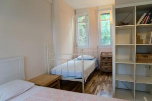 a bedroom with two beds and a book shelf at Lovely apartm.near airport in Kardiá