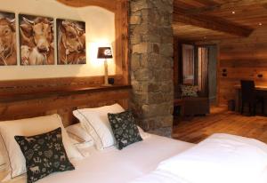 a bedroom with a white bed and a stone wall at Les Trompeurs chez Odette in Cogne