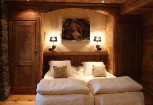 1 dormitorio con 1 cama con un cuadro de caballos en la pared en Les Trompeurs chez Odette, en Cogne