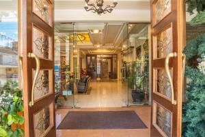 an open door into a lobby with plants at Hotel Pella in Giannitsa